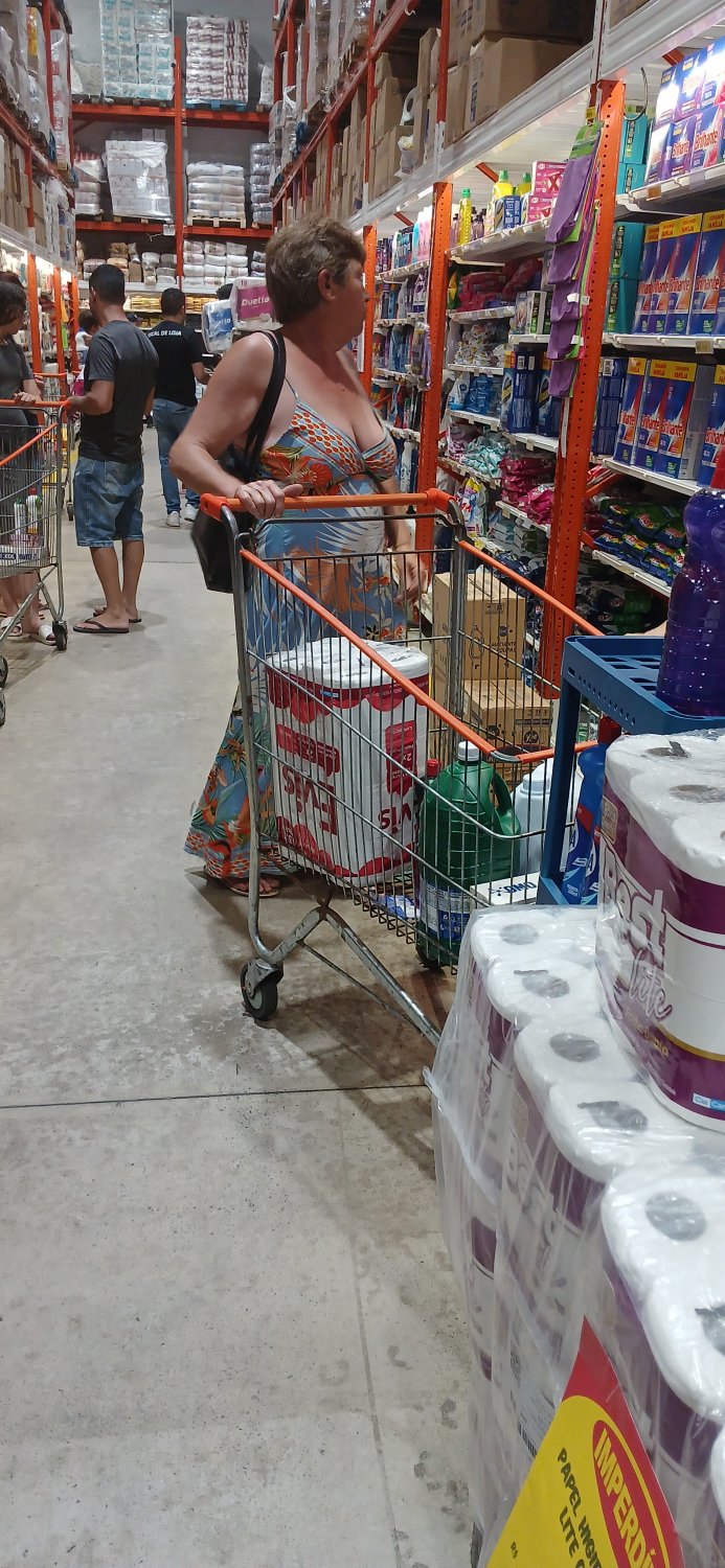 Old woman wearing a dress without a bra and with a very low neckline. #1Oo5bpxp